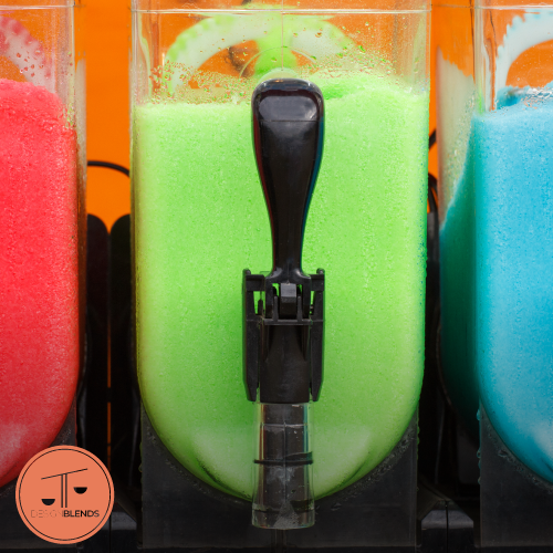 Close-up of colorful slush machines filled with red, green, and blue frozen drinks, featuring the Design Blends logo in the corner